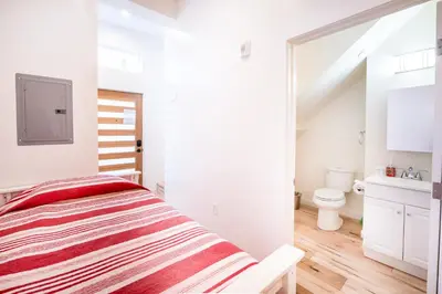 a white bedroom with a bed and a bathroom at New York loft- style 3 levels 2 Bath by Hollywood in Los Angeles