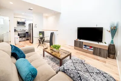 a living room with a couch and a flat screen tv at New York loft- style 3 levels 2 Bath by Hollywood in Los Angeles