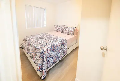a small bedroom with a bed with a floral bedspread at Cozy Koreatown/Hollywood 2 Bedroom in Los Angeles