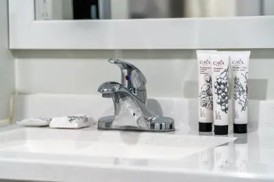 a bathroom sink with toothbrushes and a faucet at ERTH INN by AGA- Bell Garden in Bell Gardens