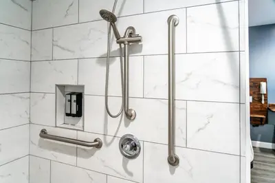 a shower with white marble tiles at ERTH INN by AGA- Bell Garden in Bell Gardens