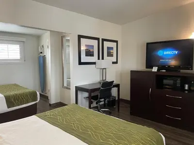 a hotel room with a bed and a flat screen tv at Hi View Inn & Suites in Manhattan Beach