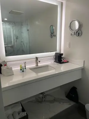 a bathroom with a sink and a large mirror at Hi View Inn & Suites in Manhattan Beach