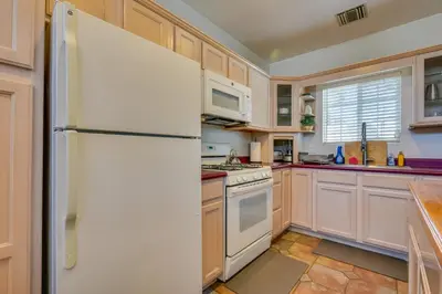 a kitchen with white appliances and a refrigerator at Luxe Pasadena Casita with Fireplace and Grill in Pasadena