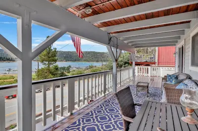 a porch with a table and chairs and a view of the water at North Shore Chalet by Big Bear Vacations Lakeside Fawnskin Estate Boat Dock Lake Access in Fawnskin