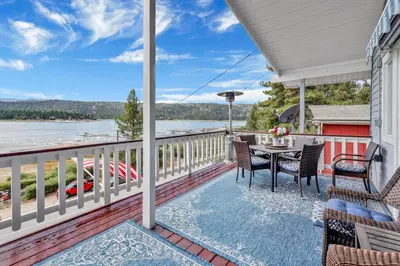 a balcony with a table and chairs and a view of the water at North Shore Chalet by Big Bear Vacations Lakeside Fawnskin Estate Boat Dock Lake Access in Fawnskin