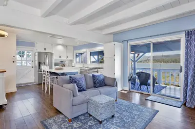a living room with a couch and a kitchen at North Shore Chalet by Big Bear Vacations Lakeside Fawnskin Estate Boat Dock Lake Access in Fawnskin
