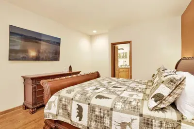 a bedroom with a bed and a painting on the wall at The Spa at Winterset- Incredible Resort Estate Chalet- Indoor Hot Tub- Games in Big Bear Lake