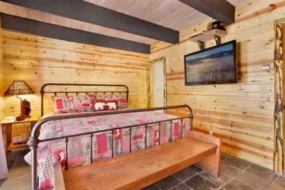 a bedroom with a bed and a wooden wall at Smith Chalet at Snow Summit- Furnished Resort Condo- Foosball- Walk To Lifts in Big Bear Lake