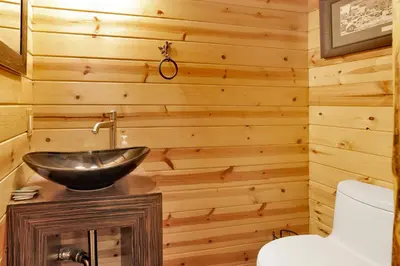 a bathroom with a sink in a wooden wall at Smith Chalet at Snow Summit- Furnished Resort Condo- Foosball- Walk To Lifts in Big Bear Lake