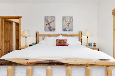 a bedroom with a large white bed with two lamps at Cozy Lakeview Hideaway by Big Bear Vacations Amazing Fawnskin Log Cabin Chalet in Fawnskin