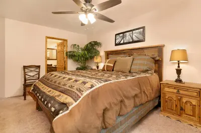 a bedroom with a large bed and a ceiling fan at Swiss Delight by Big Bear Vacations Hot Tub Game Tables Central in Big Bear Lake