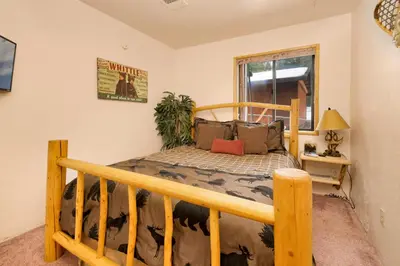 a bedroom with a wooden bed in a room at Swiss Delight by Big Bear Vacations Hot Tub Game Tables Central in Big Bear Lake