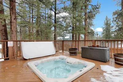 a hot tub sitting on a deck with a television at Swiss Delight by Big Bear Vacations Hot Tub Game Tables Central in Big Bear Lake
