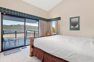 a bedroom with a bed and a balcony with a view at Forest Shores Lake View Condo by Big Bear Vacations Lakefront Village in Big Bear Lake