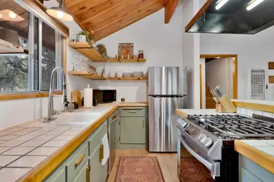a kitchen with a stainless steel refrigerator and counters at The Lost Compass- Hot Tub- Games- Walk To Lake or Marina in Big Bear Lake