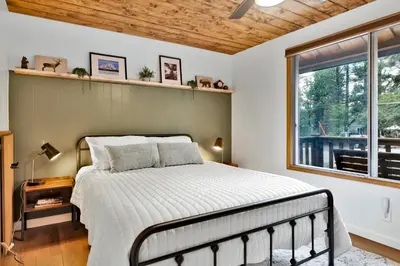 a bedroom with a bed and a window at The Lost Compass- Hot Tub- Games- Walk To Lake or Marina in Big Bear Lake