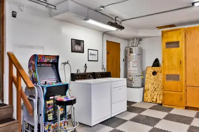 a kitchen with a arcade game and a refrigerator at The Lost Compass- Hot Tub- Games- Walk To Lake or Marina in Big Bear Lake