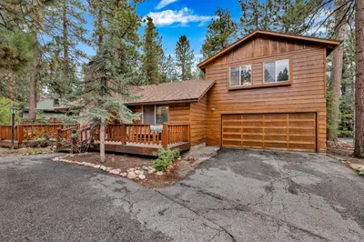 a home with a wooden house with a garage at The Lost Compass- Hot Tub- Games- Walk To Lake or Marina in Big Bear Lake