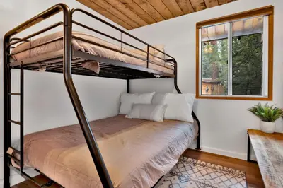 a bedroom with a bunk bed and a window at The Lost Compass- Hot Tub- Games- Walk To Lake or Marina in Big Bear Lake
