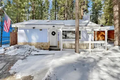 a white house with a fence in the snow at Cozy Summit- Cozy Central Resort Chalet- Minutes to Activities in Big Bear Lake