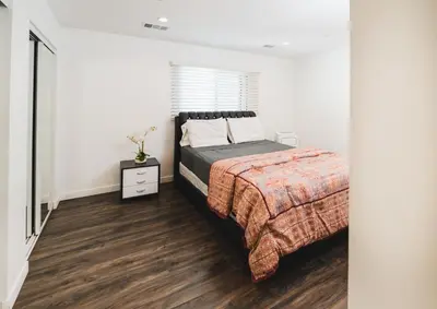 a bedroom with a bed and a wooden floor at Nice and Close to Downtown 1 Bedroom Sleeps 4 in Los Angeles