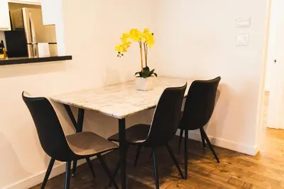 a dining room table with chairs and a vase with flowers at Cozy Koreatown 1 Bedroom Modern Furnished Free Parking in Los Angeles