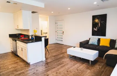 a kitchen and a living room with a couch and a table at Cozy Koreatown 1 Bedroom Modern Furnished Free Parking in Los Angeles