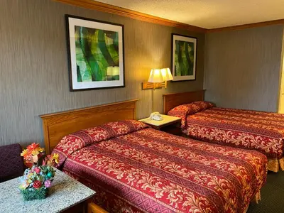 a hotel room with two beds and a lamp at New Century Inn in San Gabriel