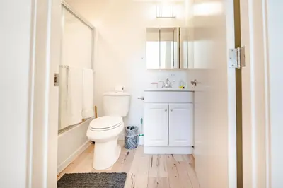 a white bathroom with a toilet and a sink at Hollywood 3Bedrooms Stylish Loft with 2 Parking in Los Angeles