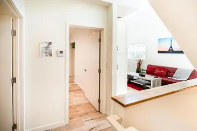a hallway with a red couch in a white room at Hollywood 3Bedrooms Stylish Loft with 2 Parking in Los Angeles