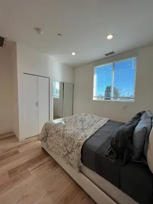 a bedroom with a large bed and a window at Modern One-Bed Loft in Hollywood Sign View & Free Parking in Los Angeles