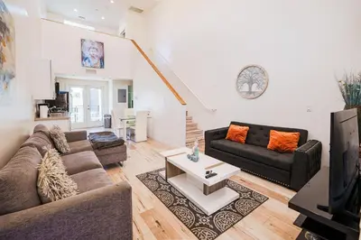 a living room with two couches and a table at Chic 1-Bed Hollywood Loft Iconic Sign Views & Private Parking in Los Angeles