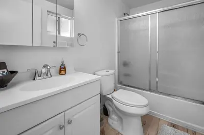 a white bathroom with a toilet and a shower at New 1 Bedroom Loft with View of Hollywood Sign in Los Angeles