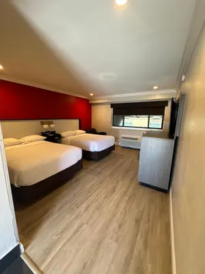 a hotel room with two beds and a window at Ramada by Wyndham Torrance in Torrance