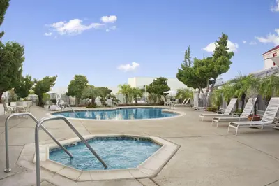 a swimming pool with lounge chairs and a swimming pool at Ramada by Wyndham Torrance in Torrance