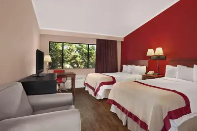 a hotel room with two beds and a television at Ramada by Wyndham Torrance in Torrance