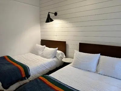 two beds sitting next to each other in a room at Sierra Motor Lodge - A Sierra Blue Hotel in Mojave