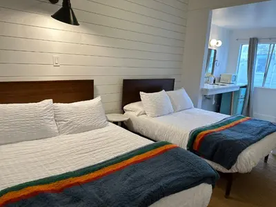 a bedroom with two beds and a sink at Sierra Motor Lodge - A Sierra Blue Hotel in Mojave