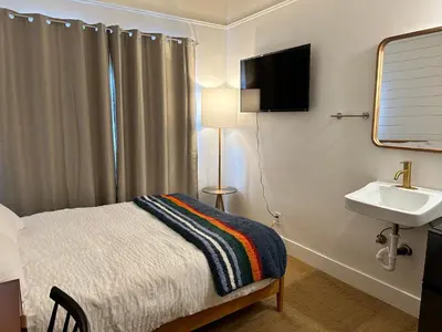 a small bedroom with a bed and a sink at Sierra Motor Lodge - A Sierra Blue Hotel in Mojave