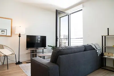 a living room with a couch and a tv at Luxury Apartment With The Hollywood Hills View in Los Angeles