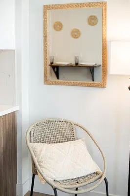 a wicker chair in a room with a mirror at Luxury Apartment With The Hollywood Hills View in Los Angeles