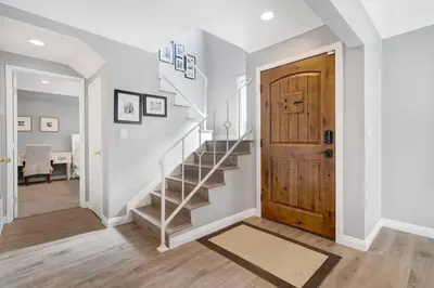 a staircase in a home with a wooden door at Private Heated Pool Oasis/Disney/Retro Arcade/Gym in Placentia