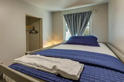 a bedroom with a blue bed with a window at Less Than 1 Mi to Big Bear Lake Fawnskin Cottage with Grill in Fawnskin