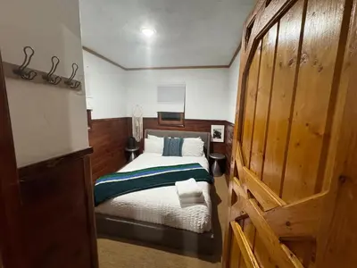 a bedroom with a bed and a wooden door at Three Pines Cabins in Big Bear Lake