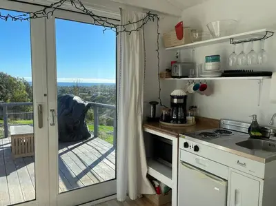 a kitchen with a sliding glass door to a balcony at 30 PCT OFF! Malibu Charming Suite, Ocean View, King Bed in Malibu