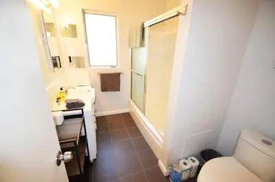 a small bathroom with a toilet and a sink at Hollywood Business Apartments in Los Angeles