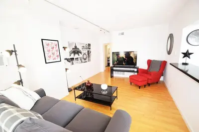 a living room with a couch and red chairs at Hollywood Business Apartments in Los Angeles