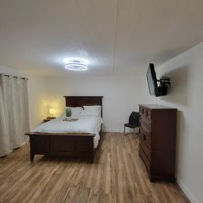 a bedroom with a bed and a dresser and a television at Buxton Private Room and Bath Wheel Chair Access in Rialto