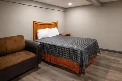 a room with a bed and a chair in it at Starlite Motel in San Bernardino